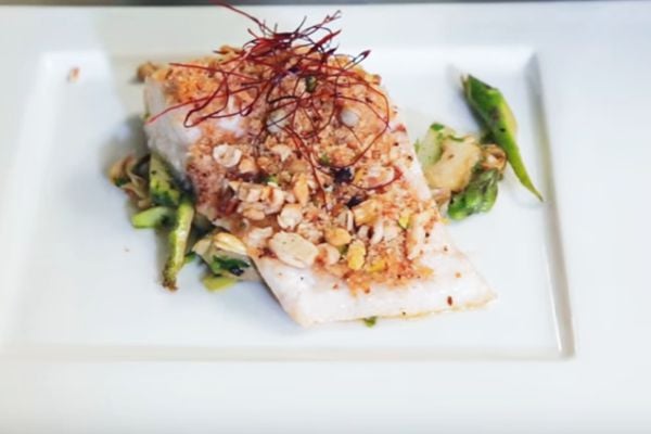 Trancio di branzino con parure di nocciole, pistacchi e pinoli su letto di carciofi e asparagi | Trattoria Conti