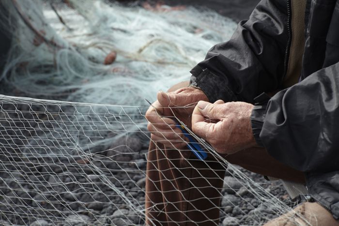 Pescatore ripara le reti